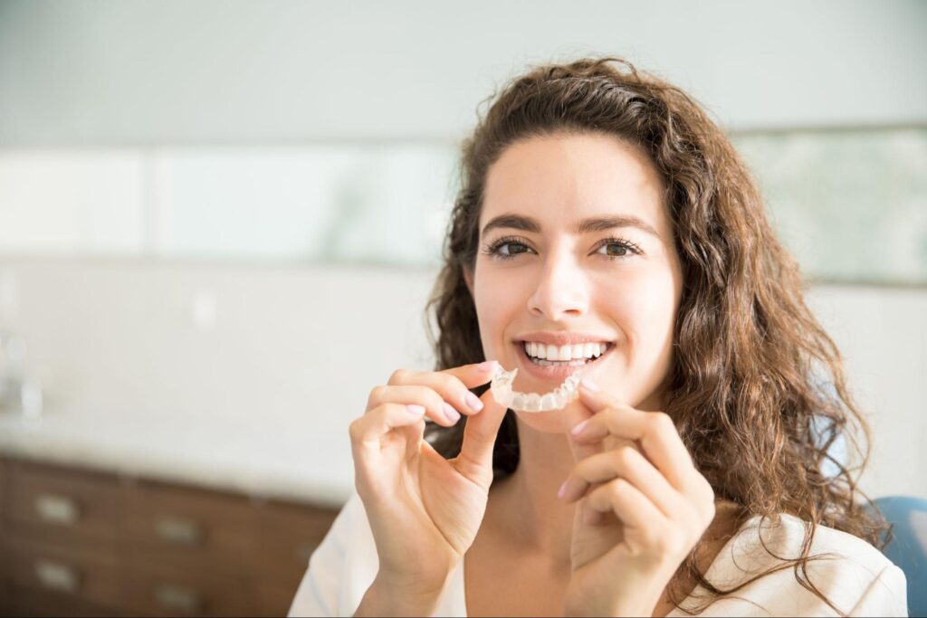 woman holding aligners
