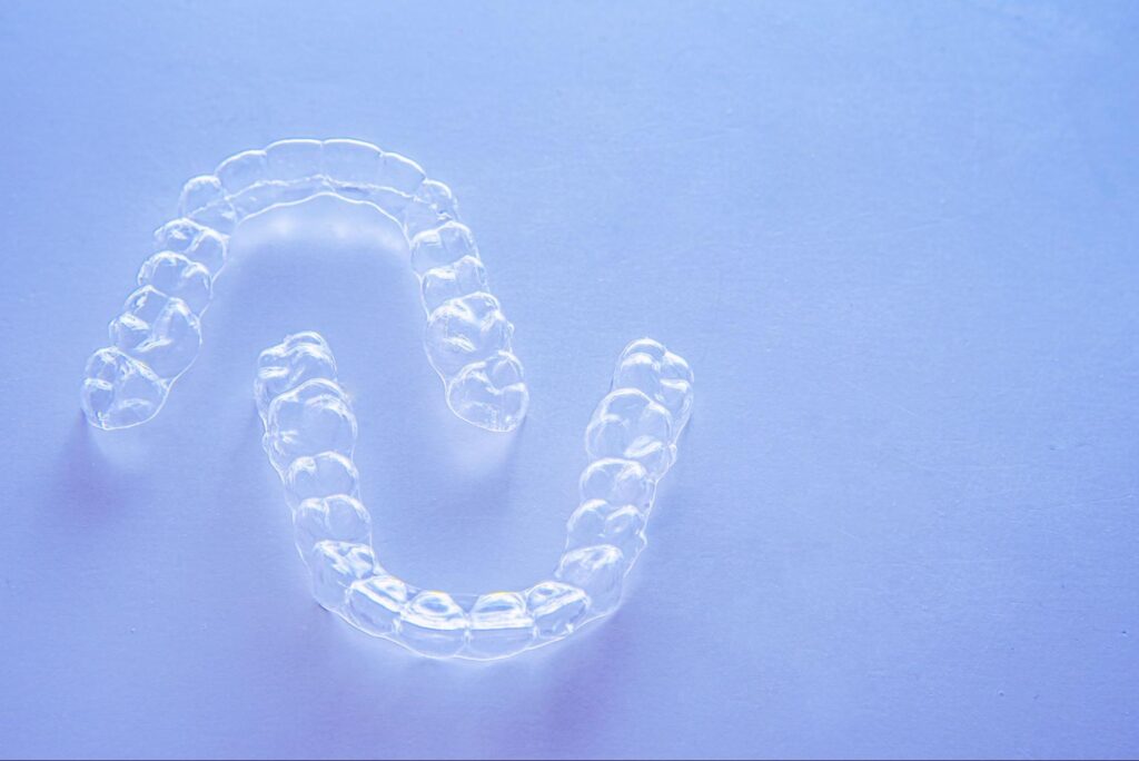 Invisalign aligners against light purple background