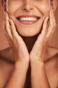 portrait woman smiling with hands by the side of her face