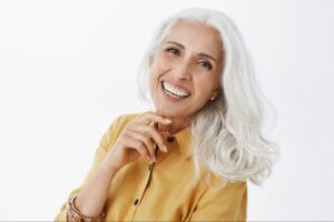 elder woman happily smiling at the camera